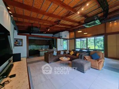 Spacious living room with modern design and open kitchen, featuring cozy seating and natural light.