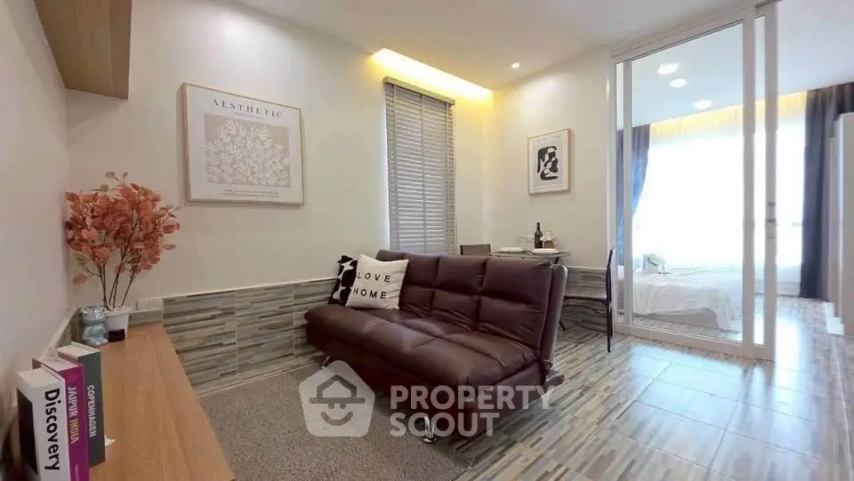 Modern living room with stylish decor and cozy ambiance, featuring a sleek sofa and elegant wall art.
