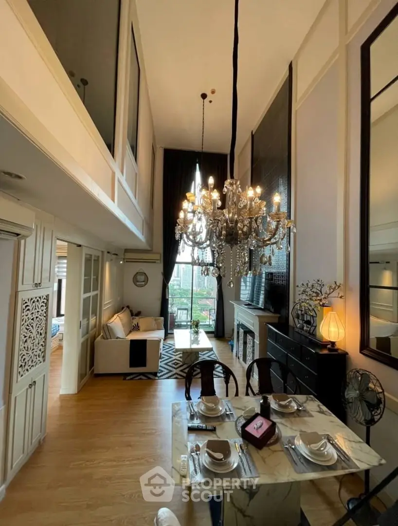 Luxurious high-ceiling living room with elegant chandelier and modern decor