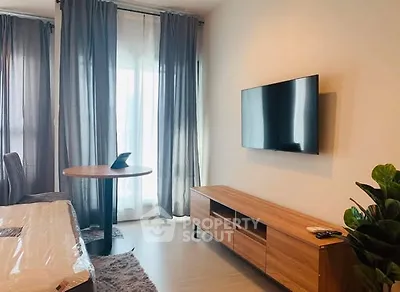 Modern living room with sleek TV, stylish wooden furniture, and elegant curtains.