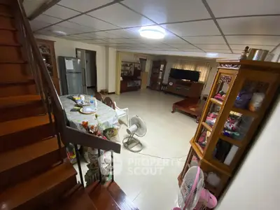 Spacious living room with dining area and wooden staircase in cozy home