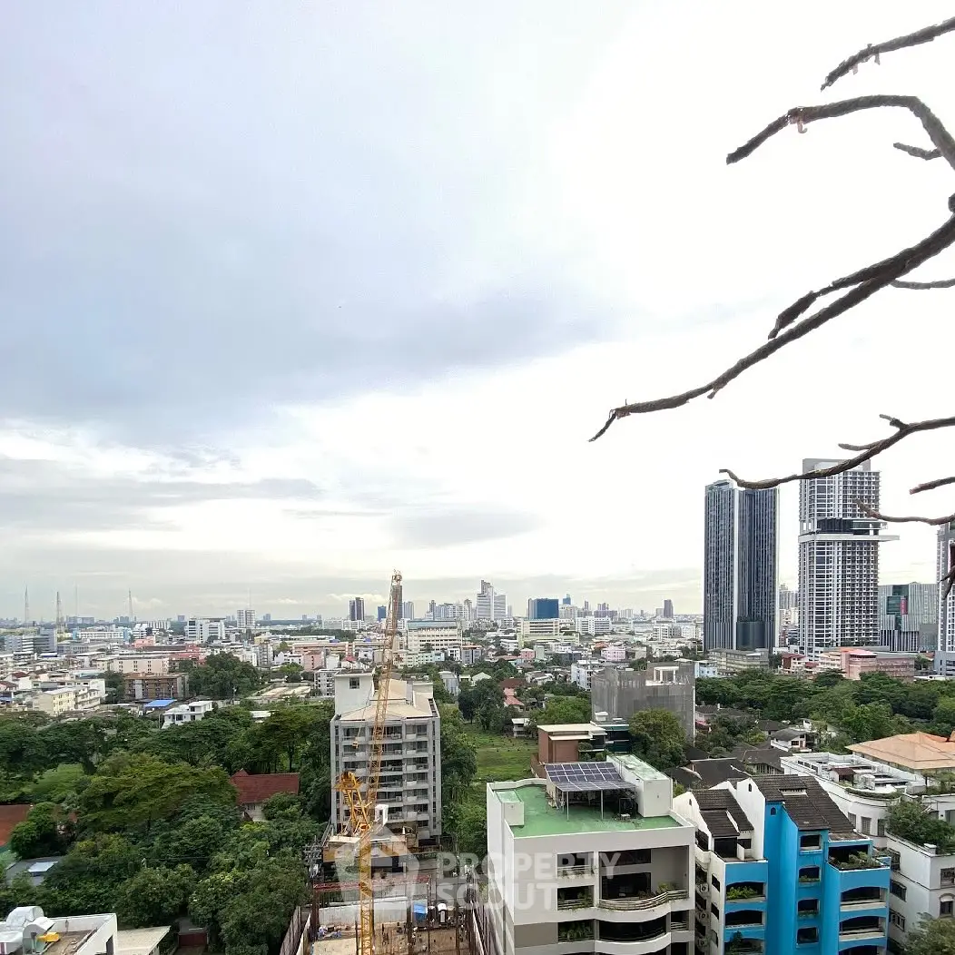 Stunning cityscape view from high-rise building showcasing urban skyline and greenery.
