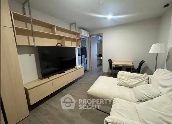 Modern living room with sleek furniture and large TV, perfect for relaxation and entertainment.