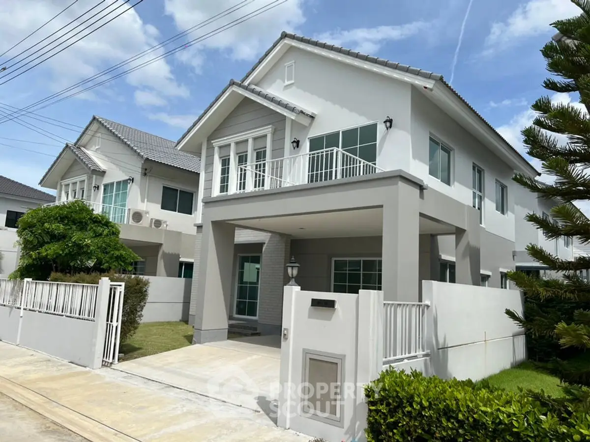 Modern two-story house with a spacious driveway and lush greenery, perfect for family living.