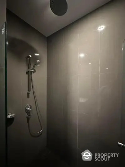 Modern bathroom shower area with sleek gray tiles and rainfall showerhead