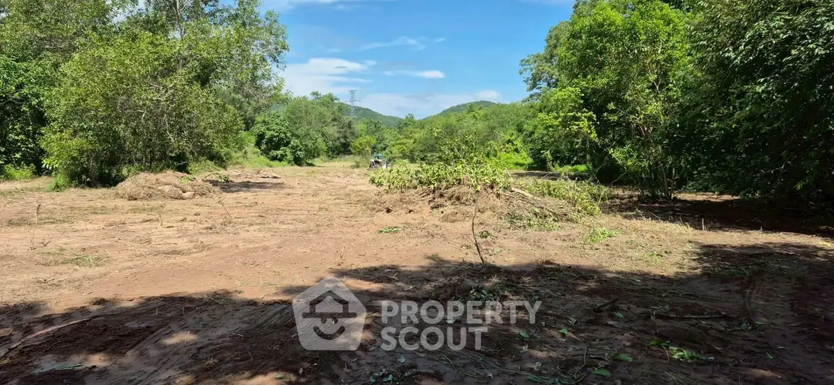 Expansive plot of land surrounded by lush greenery, perfect for development or investment opportunities.