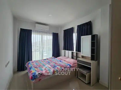 Bright and cozy bedroom with modern furnishings and large windows for natural light.
