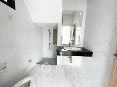Modern bathroom with sleek fixtures and spacious shower area in a contemporary home.