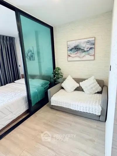 Cozy small living area with modern decor and glass partition to bedroom