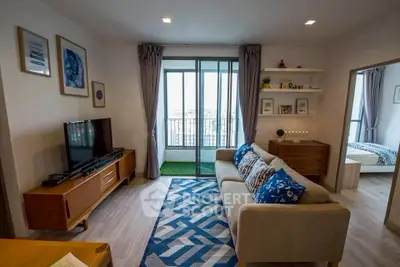 Stylish living room with modern decor and balcony view in urban apartment.