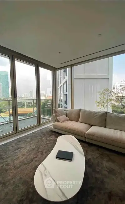 Luxurious living room with floor-to-ceiling windows and stunning city view.