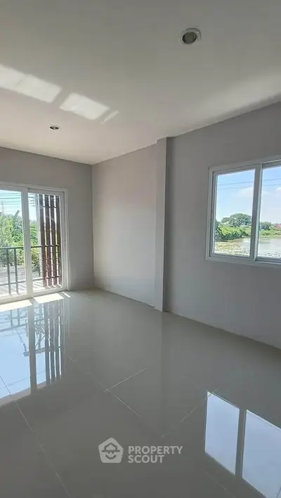 Spacious empty room with large windows and balcony access, perfect for customization.