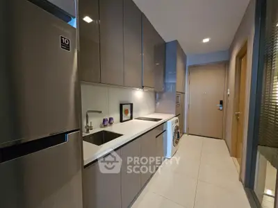 Modern kitchen with sleek cabinetry and integrated appliances in a stylish apartment.