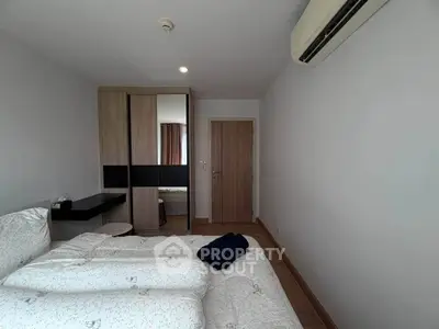 Modern bedroom with sleek wardrobe and air conditioning in a stylish apartment.
