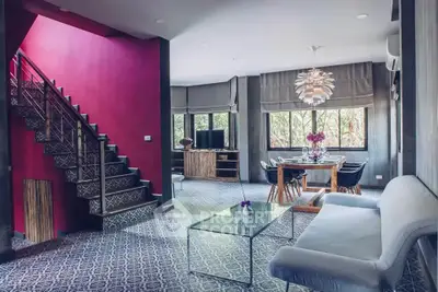 Stylish modern living room with vibrant red accent wall and elegant dining area