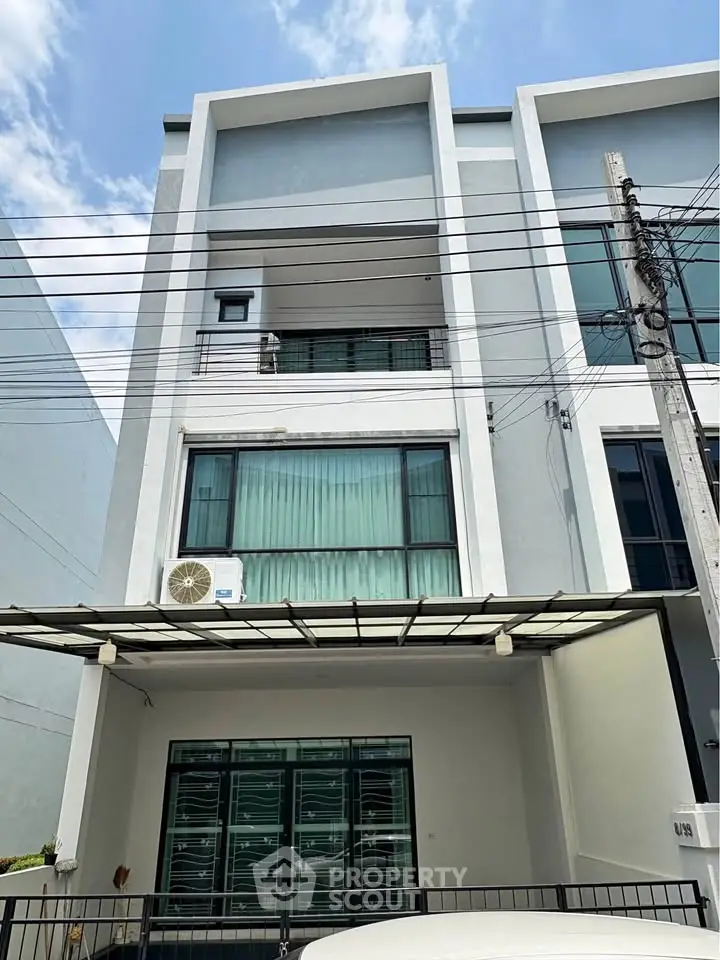 Modern three-story townhouse with sleek facade and large windows, perfect for urban living.