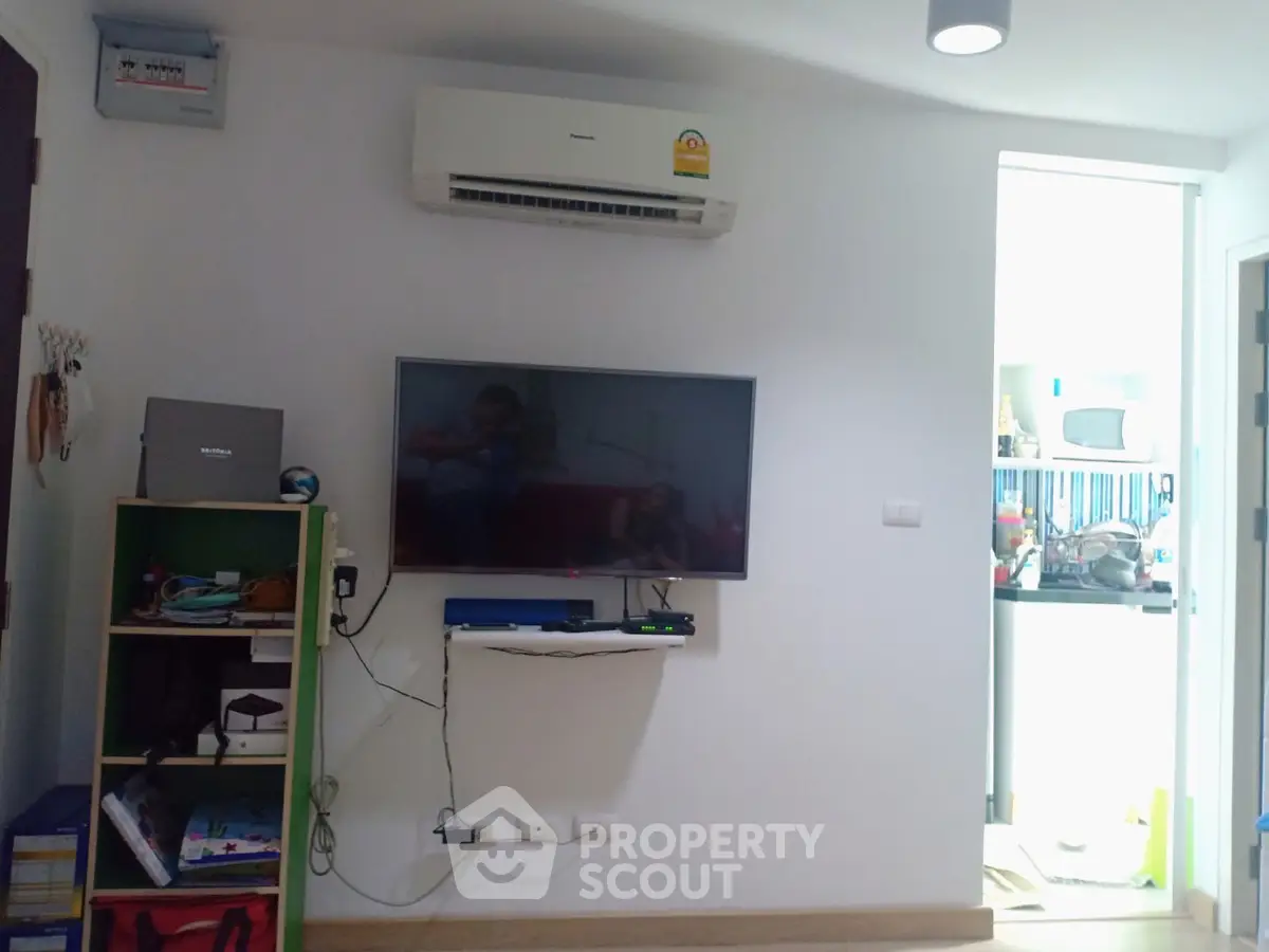 Modern living room with wall-mounted TV and air conditioning unit, showcasing a cozy and functional space.