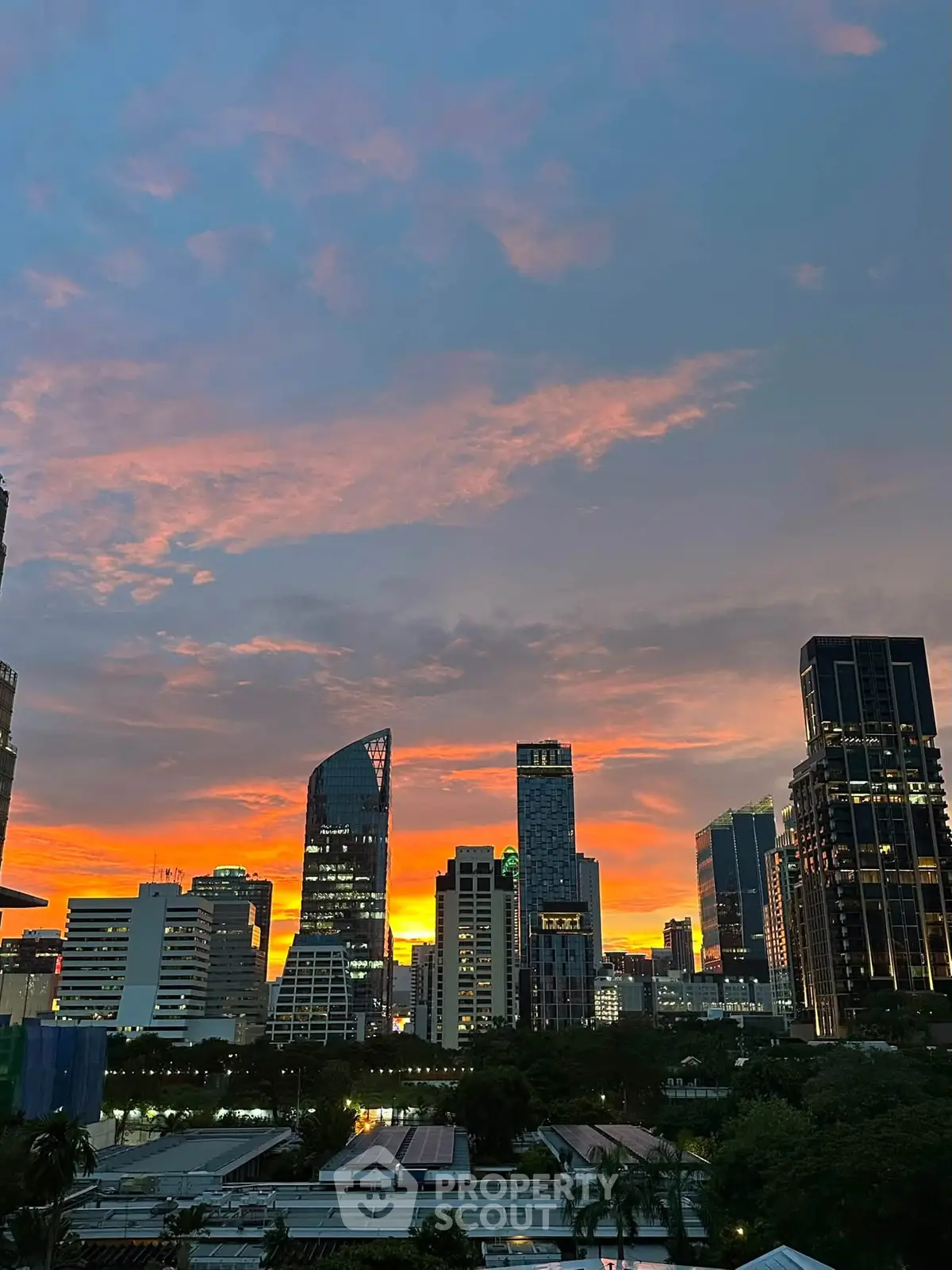 Stunning city skyline at sunset with modern skyscrapers and vibrant sky colors.