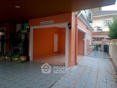 Spacious garage area with tiled flooring and orange walls in a residential property