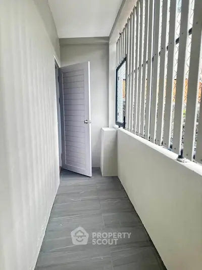 Charming narrow balcony with sleek gray tiles and modern railing, perfect for urban living.