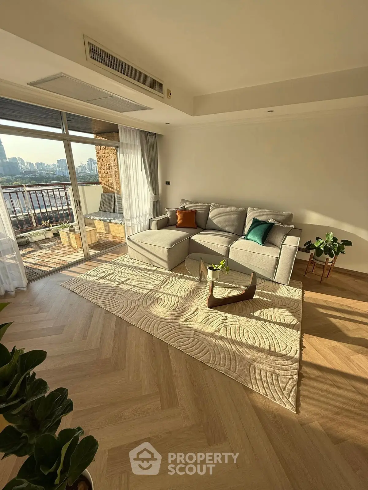 Spacious living room with elegant decor and stunning city view from balcony.