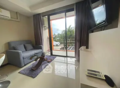 Modern living room with glass door leading to balcony and stylish furniture.