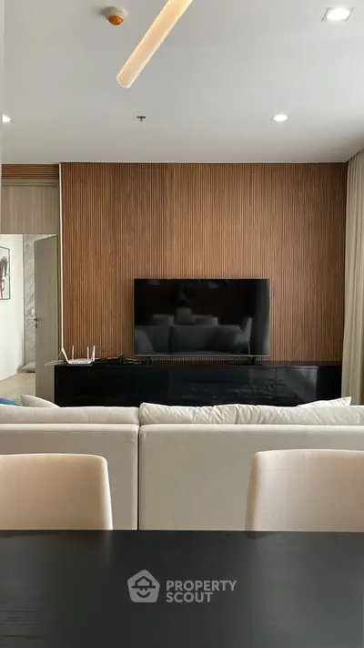 Modern living room with sleek TV setup and stylish wood paneling.