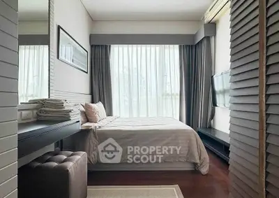 Modern bedroom with large window, stylish decor, and natural light