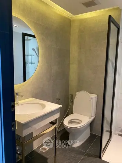 Modern bathroom with round mirror and elegant lighting