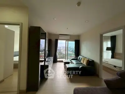 Spacious living room with city view and modern furnishings in a high-rise apartment.