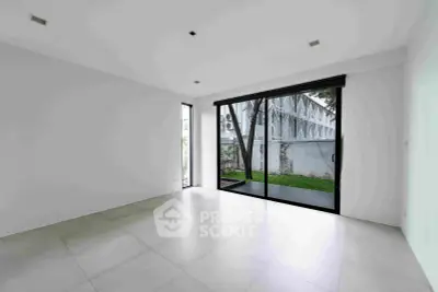 Spacious empty room with large windows and garden view, perfect for customization.