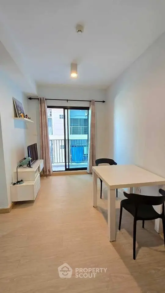 Modern minimalist living room with balcony view, featuring sleek furniture and natural light.