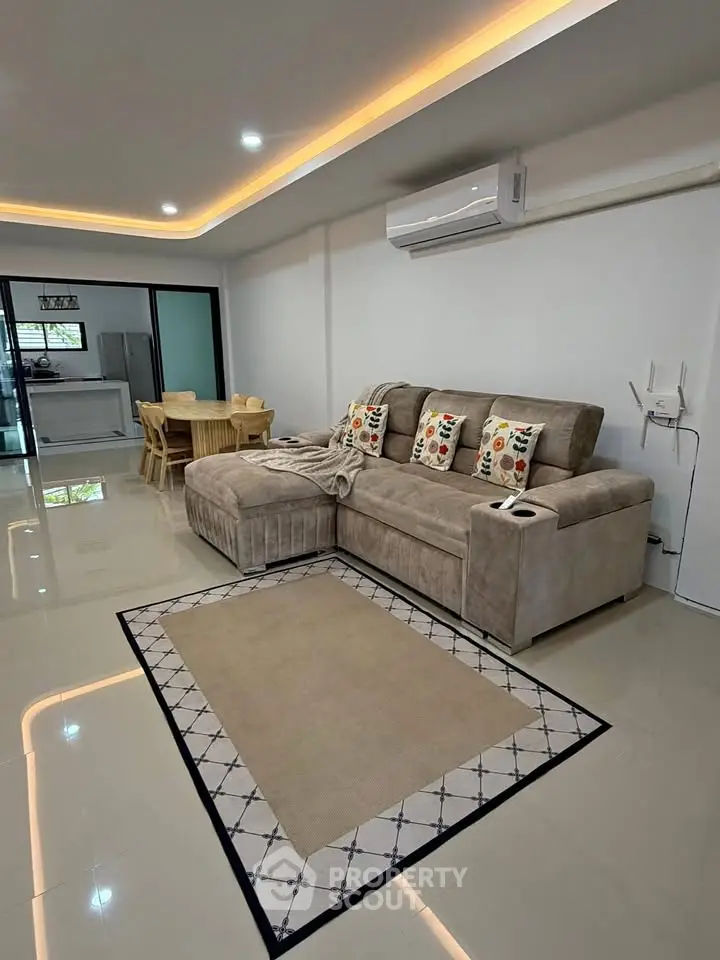 Spacious living room with modern decor and open layout, featuring a cozy sectional sofa and dining area.