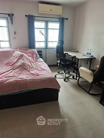 Cozy bedroom with workspace, featuring a comfortable bed and desk area, ideal for relaxation and productivity.