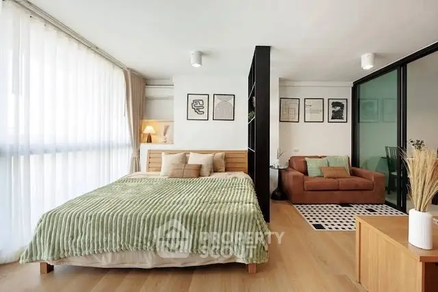 Modern studio apartment with open layout, featuring a cozy bed and stylish living area.