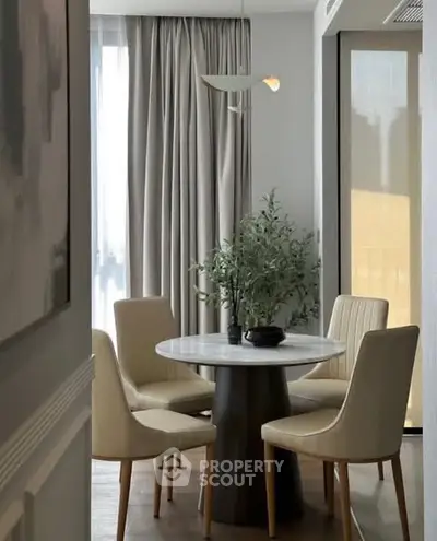 Elegant dining area with round table and modern chairs, perfect for intimate gatherings.