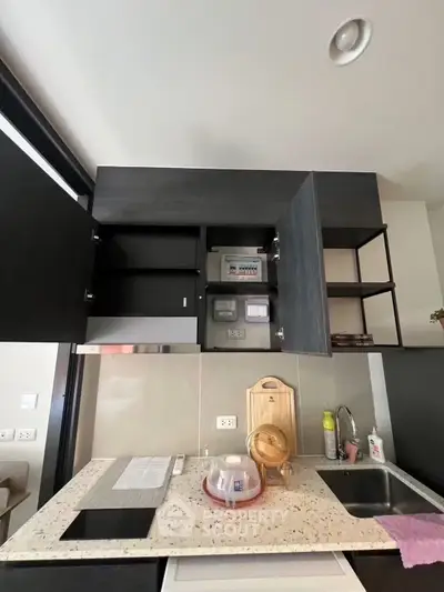 Modern kitchen with sleek cabinets and granite countertop in a stylish apartment.