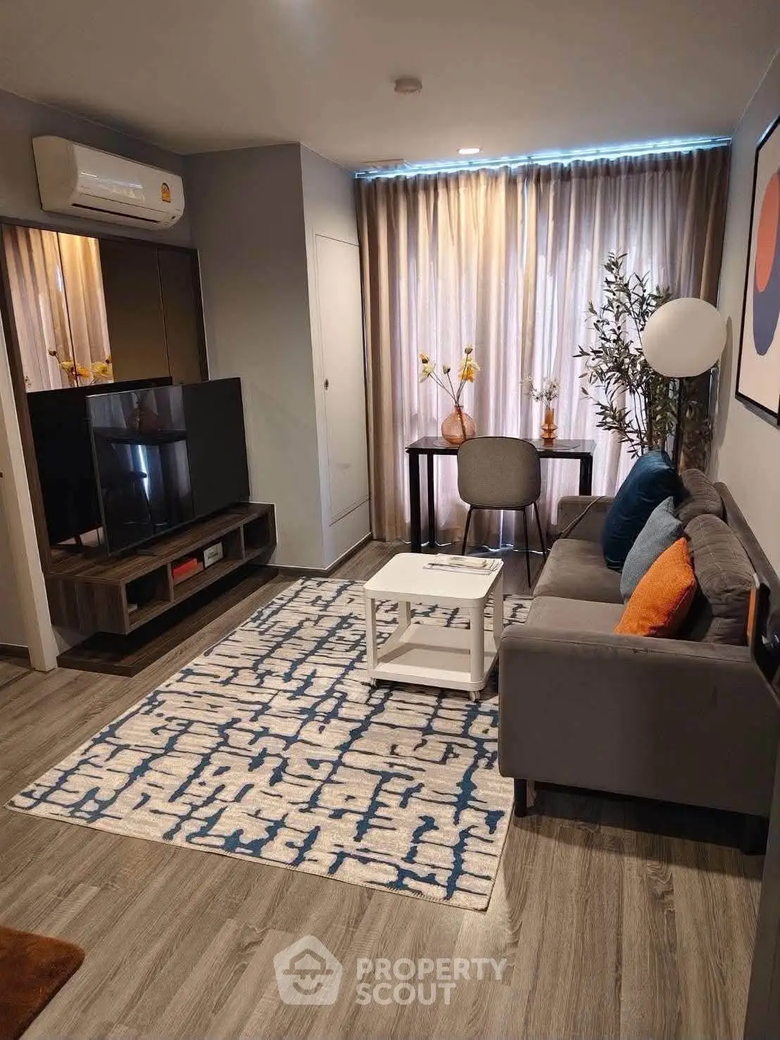 Modern living room with stylish decor, cozy sofa, and large TV, perfect for relaxation and entertainment.