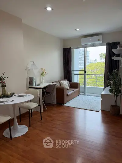 Chic living room with balcony view, modern decor, and cozy seating in a stylish apartment.