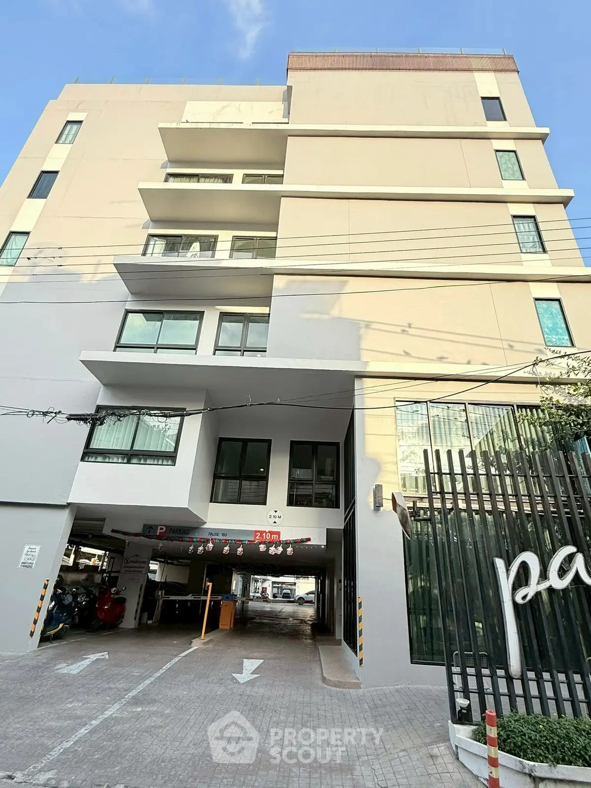 Modern apartment building exterior with parking area and contemporary design.