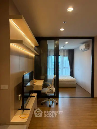 Modern apartment with study area and bedroom, featuring sleek design and ambient lighting.