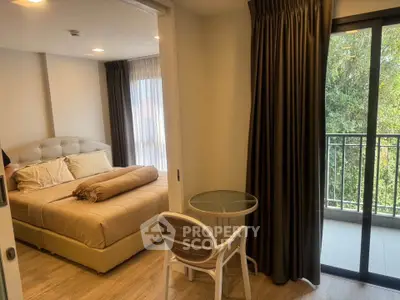 Cozy bedroom with balcony view, featuring modern decor and natural light.