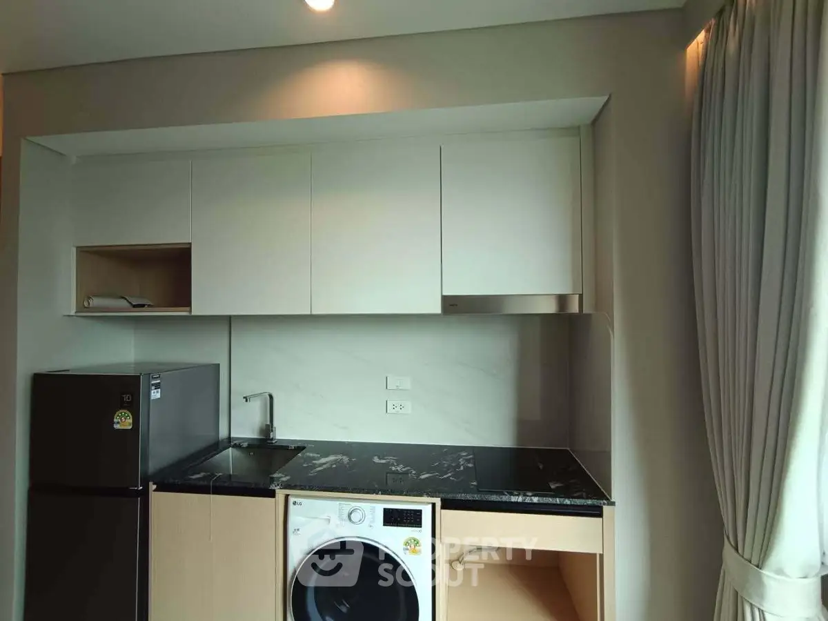 Modern kitchen with sleek appliances and elegant cabinetry in a stylish apartment.