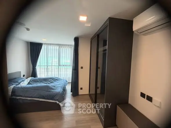 Modern bedroom with large window and air conditioning in stylish apartment.
