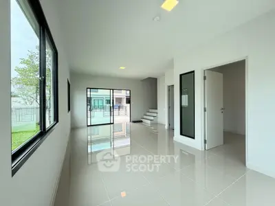 Spacious modern living room with glossy tile flooring and large windows
