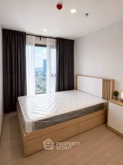 Modern bedroom with city view, featuring a minimalist design and large window for natural light.