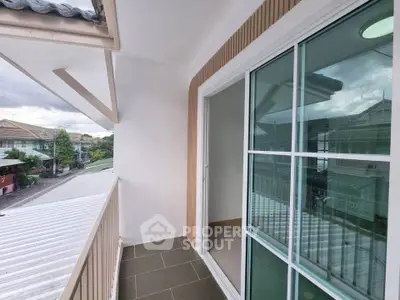 Charming balcony with sliding glass doors and scenic neighborhood view, perfect for relaxation and outdoor enjoyment.