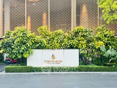 Luxurious entrance of Four Seasons Private Residences with lush greenery and elegant design.