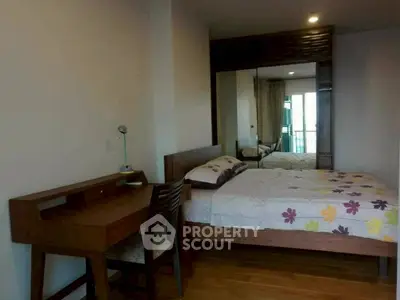 Cozy bedroom with wooden furniture and mirrored wardrobe in modern apartment