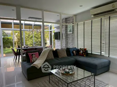 Modern living room with large sectional sofa and garden view, perfect for relaxation and entertaining.